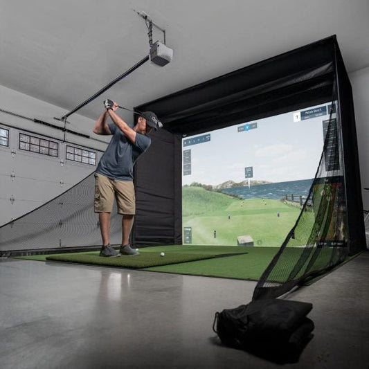 Golfer practicing indoors with Big Moss C-Series DIY Kit Pro golf enclosure with 9ft ceiling and impact screen - ALLBGT