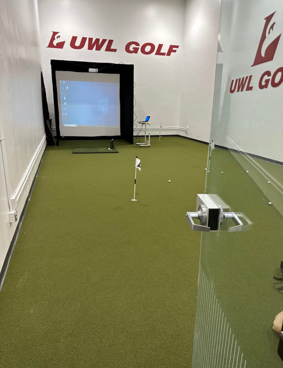 UWL Golf indoor training space with full putting surface, hitting mat, and projector - Big Moss Commander Bulk Turf - ALLBGT