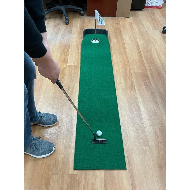 "Golfer practicing short putts on the Big Moss Office Putting Green 6-foot training mat - ALLBGT"