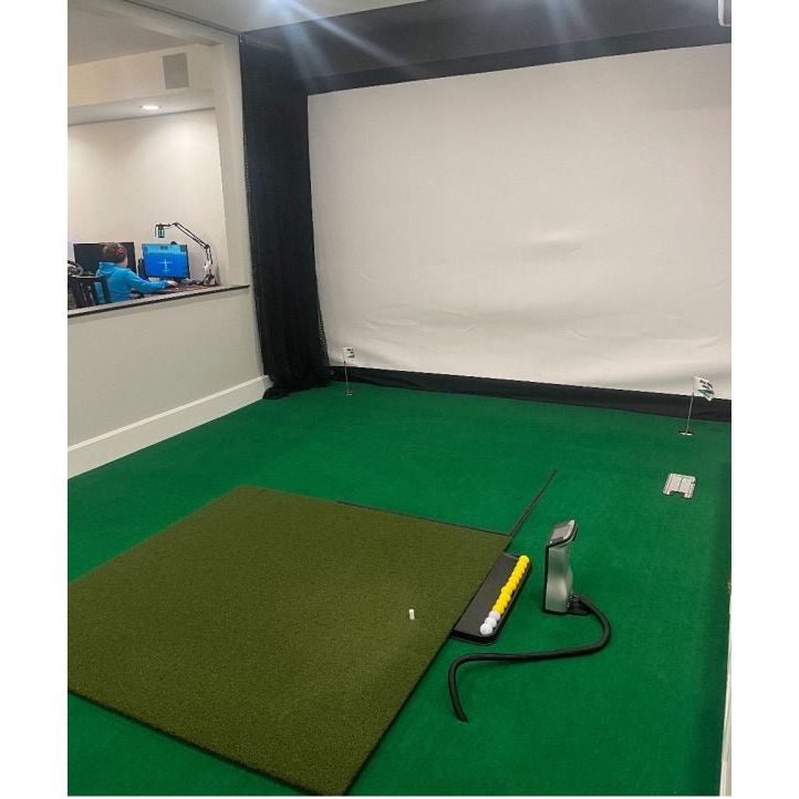 Indoor golf simulator setup featuring Big Moss True Launch PLUS 5'x10' Hitting Mat on green turf - ALLBGT