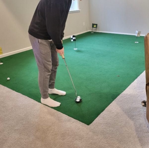 Golfer practicing short putts on Big Moss V2 Bulk Turf green setup for realistic indoor golf practice. - ALLBGT