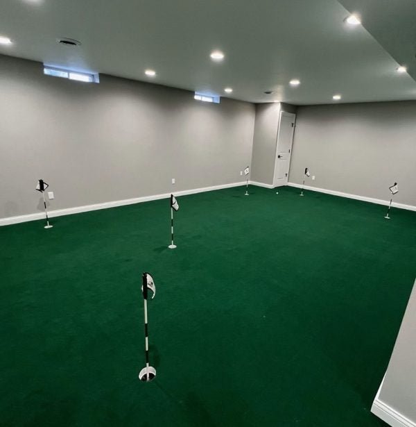 Basement golf room featuring Big Moss V2 Bulk Turf custom putting green with multiple practice holes. - ALLBGT