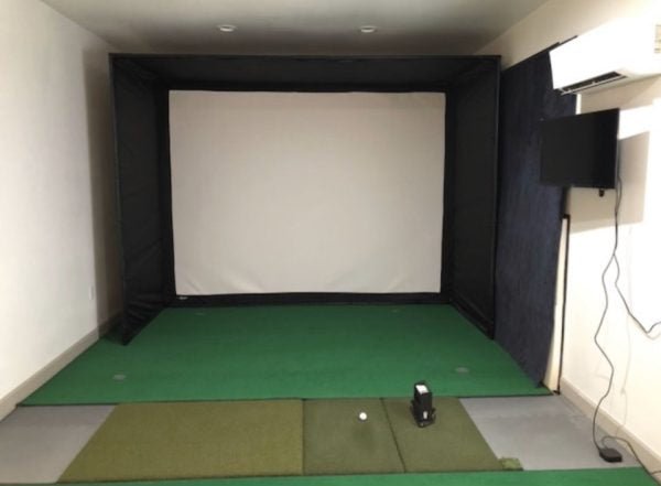 Compact indoor golf simulator with Big Moss V2 Bulk Turf custom putting green and impact screen setup - ALLBGT