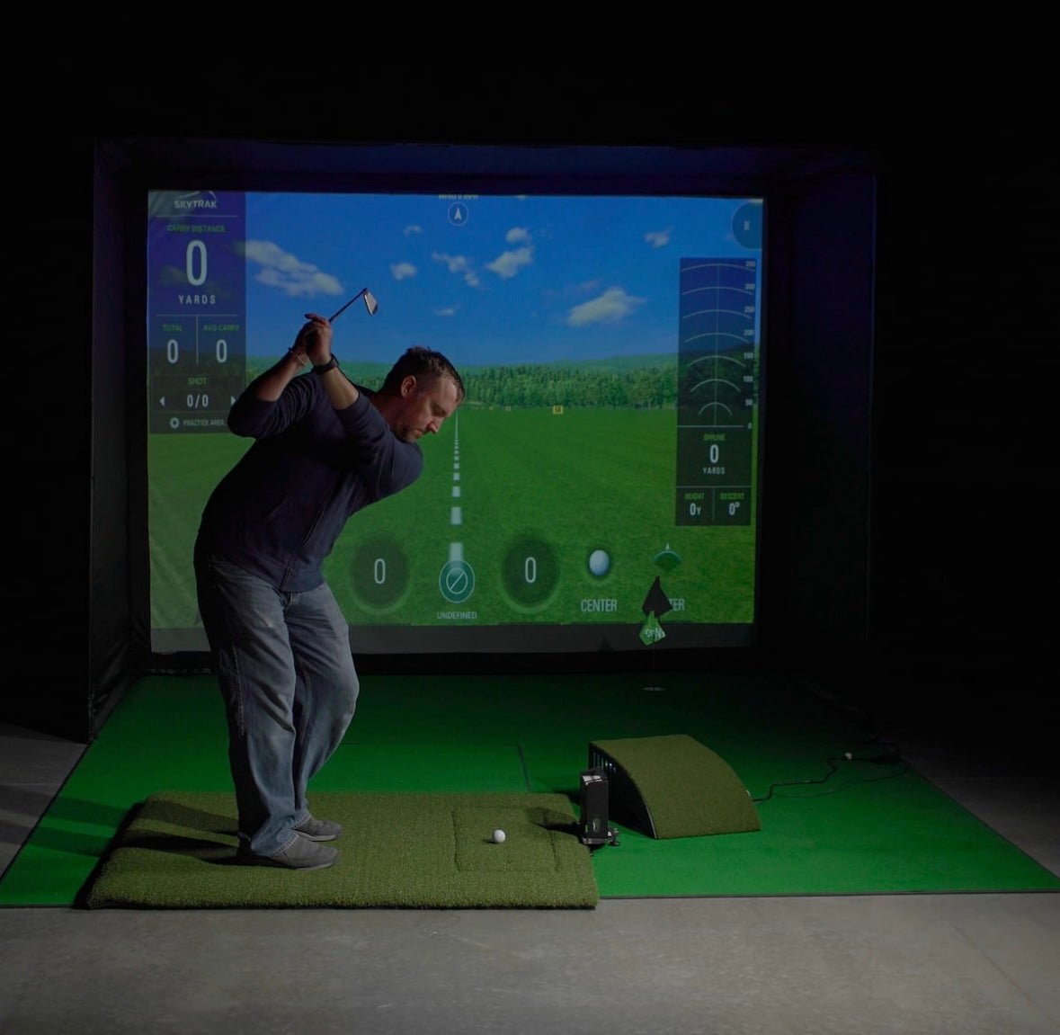 "Golfer practicing on Carl’s Place HotShot Golf Mat System inside a simulator setup - ALLBGT."