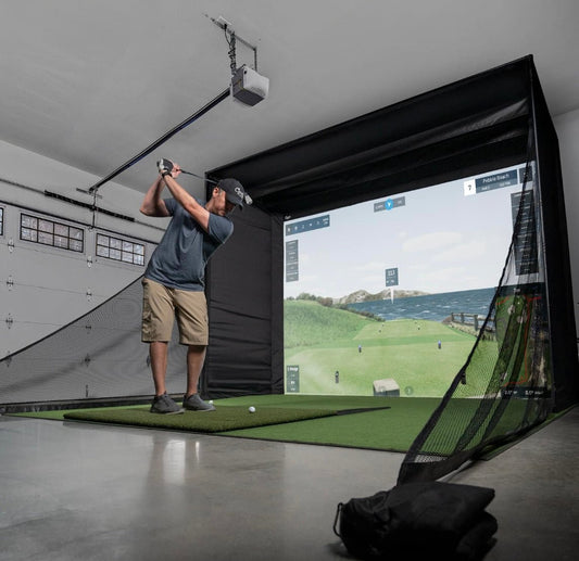 “Golfer swinging inside Carl’s Place DIY Golf Simulator Enclosure package setup in home garage - ALLBGT.”