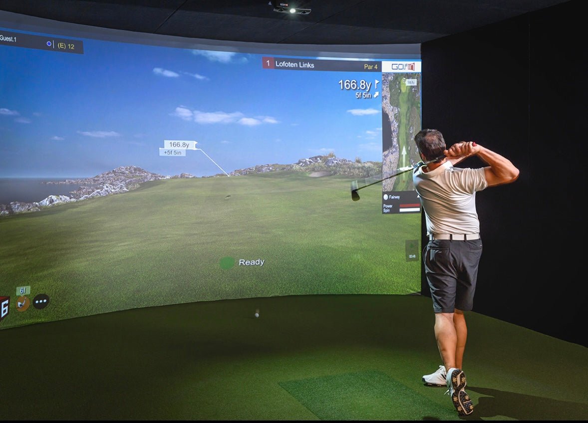 “Golfer swinging inside SimBooth 4 Golf Simulator Enclosure with curved impact screen - ALLBGT”