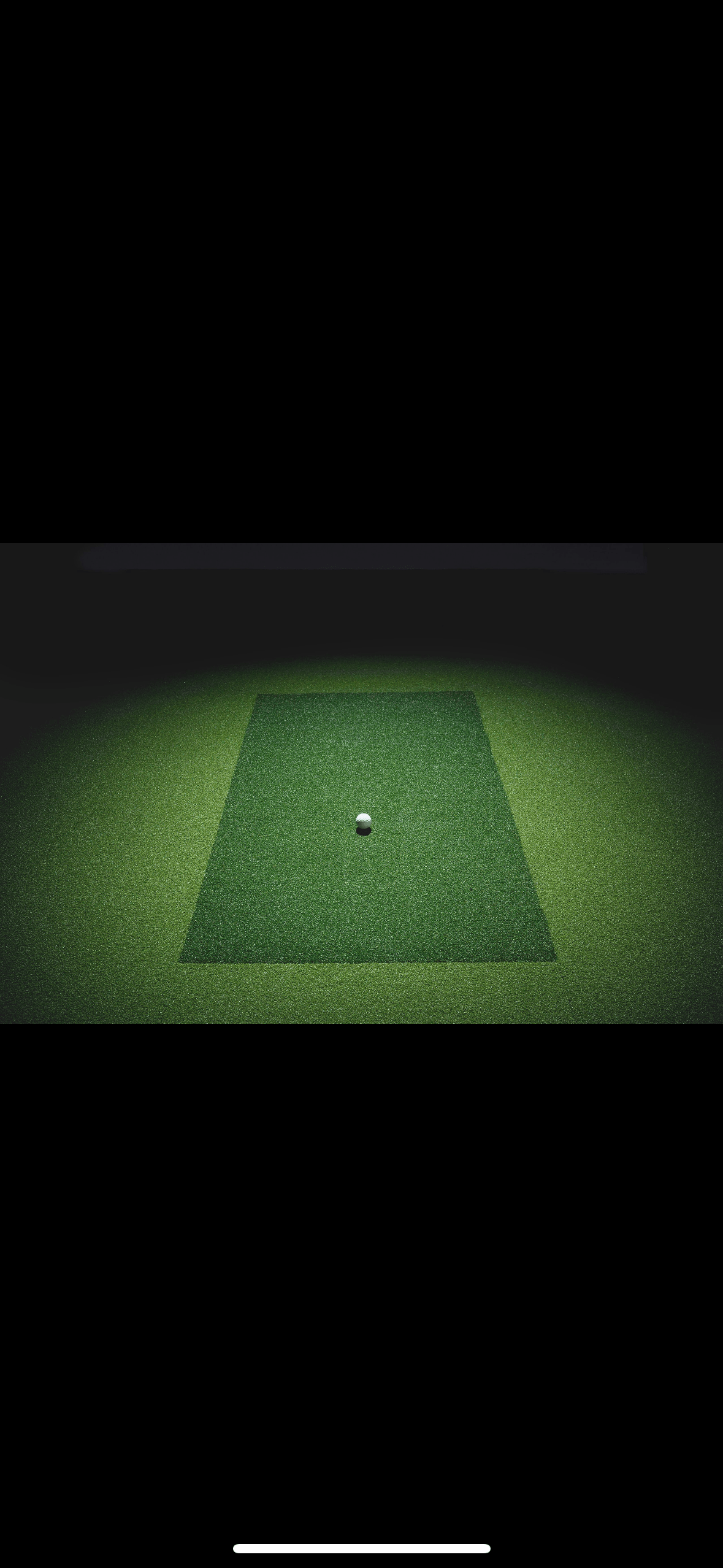 "SimBooth 1 integrated hitting mat and green floor surface with centered golf ball under lighting - ALLBGT"
