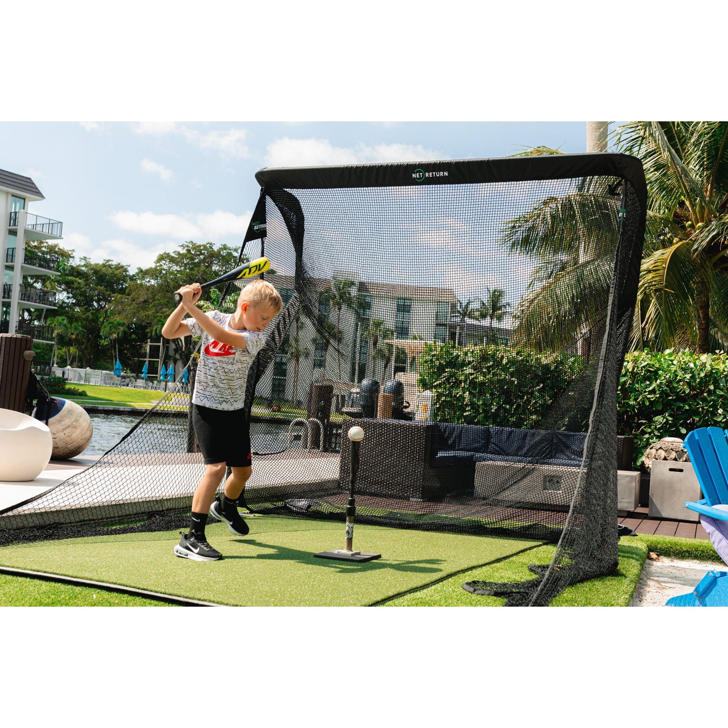 “Child practicing baseball swings with The Net Return Pro Package - Pro Series setup on turf mat - ALLBGT.”