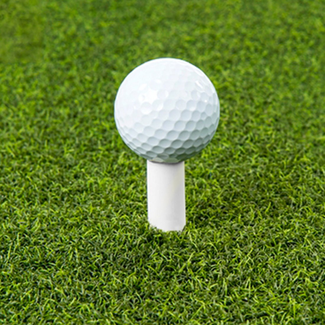 On turf view - The Net Return Rubber Tee holding golf ball on green hitting mat for practice or simulator setup - ALLBGT