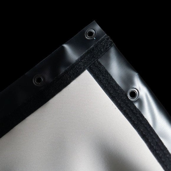 Close-up of SIGPRO premier golf simulator enclosure screen corner where black and white fabric meet on a black background