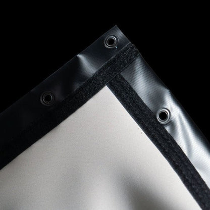 Close-up of SIGPRO premier golf simulator enclosure screen corner where black and white fabric meet on a black background
