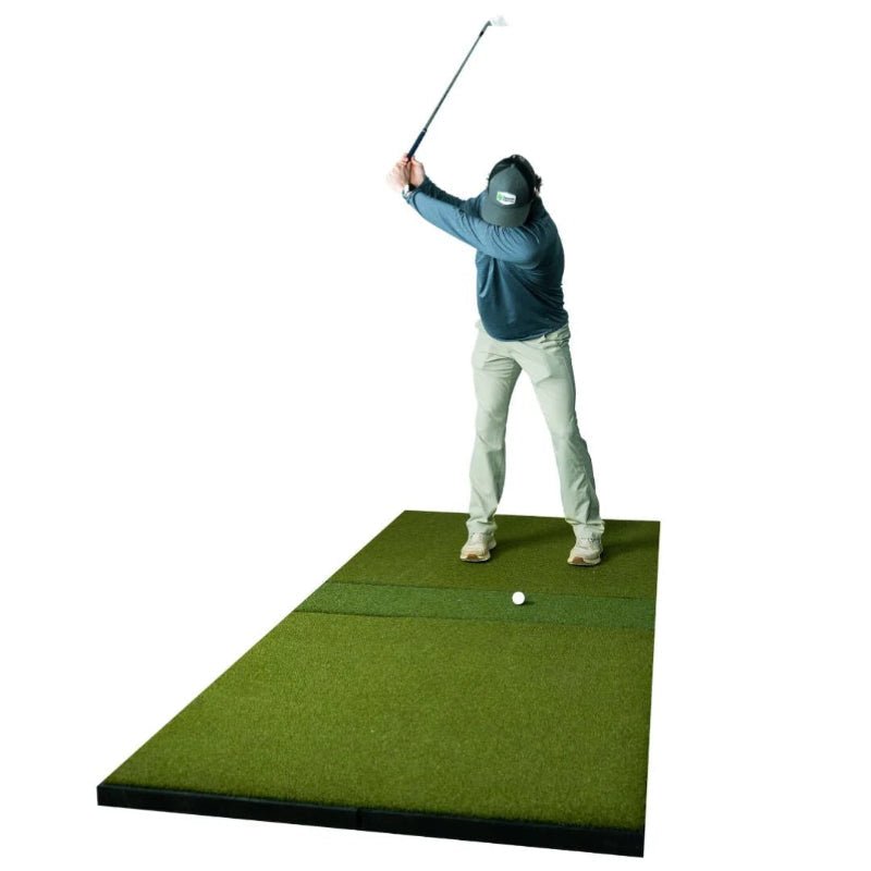 Golfer practicing on SIGPRO Super Softy 4x9 golf mat indoor simulator hitting mat realistic turf feel.